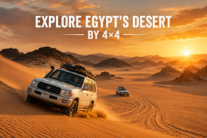 4×4 vehicles driving across Egypt’s golden desert dunes at sunset, surrounded by rugged mountains and vast Sahara scenery.