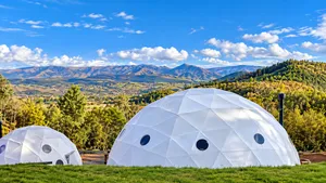 Organic Farm Dome Stay, Maras: Sustainable Living Amidst Andean Beauty 1 White geodesic glamping domes overlooking rolling farmland, green hills, and dramatic Andean mountains near Maras in Peru’s Sacred Valley.