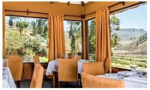 🏕️ Colca Canyon Adventure Camp – A Luxurious Wilderness Retreat 3 Restaurant at Colca Canyon with table and chairs with large windows and view of the canyon.