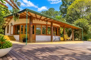 Lakeside Cabins At Represa De Guarapiranga: A Waterside Glamping Escape 2 Lakeside cabin with a spacious wooden deck surrounded by lush tropical greenery near Represa de Guarapiranga, São Paulo, Brazil.