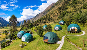Green geodesic glamping domes nestled on a grassy mountainside in Peru's Sacred Valley, featuring winding stone pathways, lush greenery, towering Andean mountains, and a bright blue sky with white clouds.