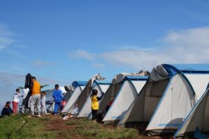 Organic Farm Dome Stay, Maras: Sustainable Living Amidst Andean Beauty 3 Several camping tents with people on high ground in the mountains on a sunny day.