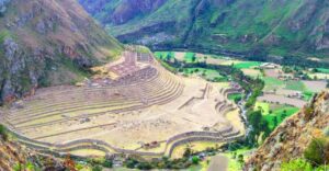 🏞️ Luxury Inca Trail Tours (4 Days) – Trek In Style 1 Deep valley with trees and vegetation and fields with mountains.