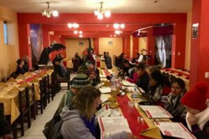 🌄 Colca Canyon Eco Retreat – Sustainable Glamping In The Andes 2 People sitting at tables looking at menu's of what to eat at a restaurant.