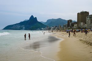 ✨ Rio De Janeiro Glamping Hub: Luxury Nature Stays in Brazil’s Most Vibrant City 3 Ipanema Beach in Rio de Janeiro, Brazil, with visitors enjoying the sandy shoreline, Atlantic Ocean waves, beachfront buildings, and Two Brothers mountains in the distance.