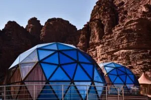 Cliffside Dome, Vidigal – Panoramic Ocean Views Above Rio 3 Blue geodesic glamping domes surrounded by towering red rock cliffs in a dramatic canyon landscape.