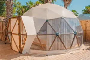 Luxury Yurt, Santa Teresa – Bohemian Comfort in Rio’s Artsy Beach District 3 Luxury glamping dome with a spacious wooden deck surrounded by palm trees and tropical greenery.