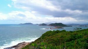 Praia dos Naufragados Beach in Florianópolis, Brazil with turquoise water, forested hills, and a quiet sandy shoreline