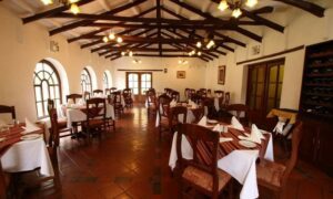 Dining room table and chairs with a wine cabinet with plates and napkins.
