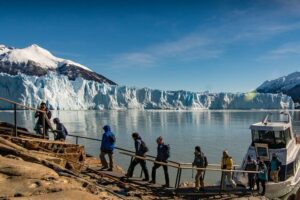 Group of tourists disembarking from a boat and walking along a path with railings in Patagonia.