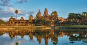 Exploring The Angkor Temple Surroundings – Cambodia’s Wildlife & Nature Adventures 1 Distant view of Angkor Temple complex from the ground, framed by surrounding trees and landscape.