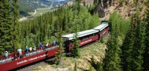 🏔️ Colorado Rockies: Wildlife Adventures & Scenic Escapes🌲 1 Train winding through scenic mountains and valleys.
