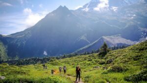 Hiker trekking along Mont Blanc in the French Alps, surrounded by snow-capped peaks, rocky trails, and panoramic mountain views.