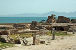 Ruins of the Antonine Baths in Carthage, Tunisia, with stone columns and arches.