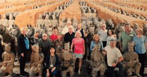 ⚔️ The Terracotta Army, Xi’an: Guardians Of China’s First Emperor🌏 2 Several visitors posing for a photo among the life-sized Terracotta Army statues in Xi’an, China.