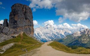 Tall, flat-topped mountain with a winding trail along the ridge and surrounding peaks in the background.