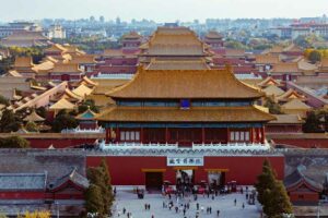 Overhead view of the Forbidden City in Beijing, China, with golden rooftops and symmetrical palace courtyards