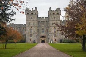 History Of Windsor CastleWindsor Castle Was Originally Built In 1070 3 Distant view of Windsor Castle and Buckingham Palace, iconic landmarks in England, with surrounding landscape.