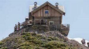 The Pradidali Refuge and alpine bivouac on a hill in the Dolomites, Italy, surrounded by dramatic cliffs and alpine scenery.