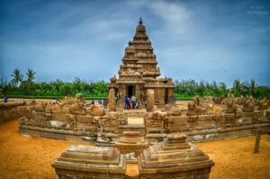 Ancient temple wall adorned with statues, palm trees in the background