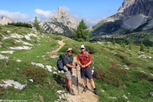Alta Via 1: Classic Dolomites Trek – A Complete Guide 4 hikers with backpacks posing for a group photo on a trail, with mountains in the background.