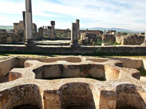 Panoramic view of the Roman ruins of Volubilis in Morocco with ancient arches and columns"