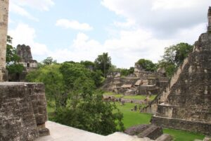 Discover The Ancient Ruins of Mexico & Central America: Chichen Itza, Tikal, and Palenque 4 Several ancient structures of Tikal in Guatemala, including pyramids and temples, viewed from above amidst lush jungle — part of the historic Brain Chamber complex