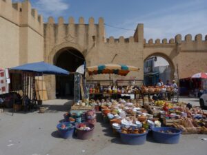 Traditional market in Kairouan’s Medina with stalls of colorful goods and locals shopping