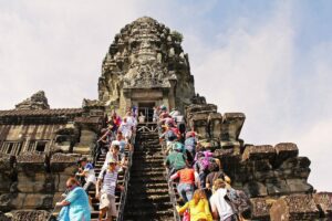 🏛️ Angkor Wat, Cambodia: A Complete Traveler’s Guide✨ 2 Several people walking to the top of Angkor Wat pyramid in Cambodia, surrounded by ancient stone terraces and temple architecture.