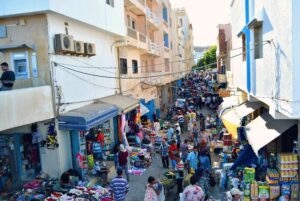Bustling market with colorful stalls selling spices, textiles, and local goods.