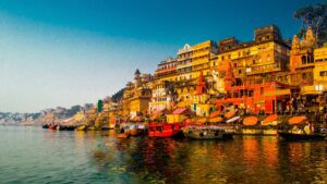 View of Varanasi with numerous buildings along the riverbank and boats on the water