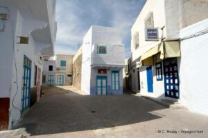 Sunlit and shaded buildings along a narrow street in Kairouan’s Medina, Tunisia