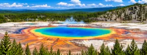 Panoramic view of Grand Prismatic Spring in Yellowstone National Park with brilliant blue, turquoise, yellow, and orange geothermal colors surrounded by forests and boardwalks.