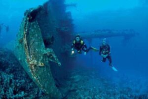 Two scuba divers exploring a mysterious shipwreck beneath the sea — an unforgettable underwater adventure 🌊🐠