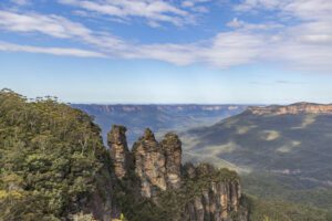 Australia – Aboriginal Heritage Sites 1 Aerial view of a tall mountain with steep cliffs overlooking a forested valley.