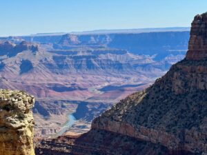 Aerial view of the Grand Canyon showcasing its vast cliffs, deep valleys, and layered rock formations.