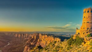 🏛️ Desert View Watchtower – Grand Canyon South Rim 1 View from Desert View Watchtower at the Grand Canyon South Rim, showing steep canyon walls, the Colorado River winding below, and expansive canyon scenery under a partly cloudy sky.