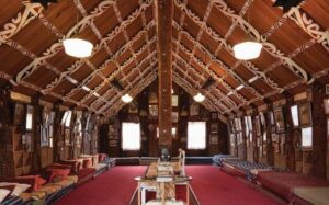 🛖 Marae Experiences Across New Zealand: Immerse In Māori Culture 3 Interior of a building with stylish bedding, pillows, and modern design elements.