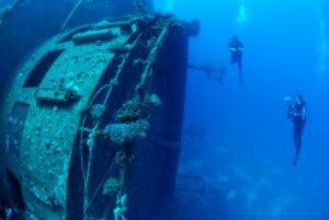 Two scuba divers exploring a mysterious shipwreck beneath the sea — an unforgettable underwater adventure 🌊🐠