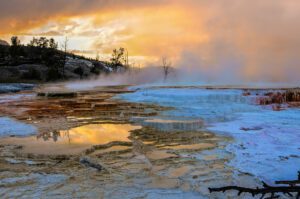 Mammoth Hot Springs in Yellowstone National Park seen from a distance, showing terraces and surrounding landscape.