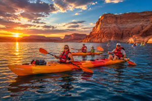 🌊 Lake Powell (Page, Arizona) Waterfront RV Camping 4 People kayaking across calm blue waters at sunset surrounded by towering red rock canyon cliffs, glowing desert landscapes, and dramatic colorful skies at Lake Powell.