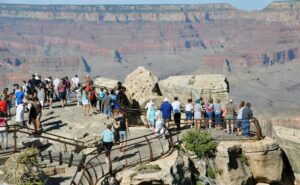 Many people standing at the top of the Grand Canyon looking out over the vast canyon landscape.