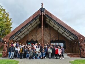 🛖 Marae Experiences Across New Zealand: Immerse In Māori Culture 2 Group of people standing and posing in front of Tangatarua Marae during an EIT Auckland visit at Toi Ohomai.