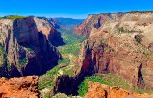 Zion National Park with tall canyon walls and green vegetation in the valley.