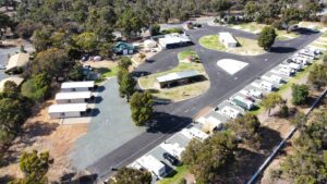Aerial view of a scenic South America trailer park showing multiple trailers, surrounding trees, and park buildings, highlighting the organized layout and natural surroundings.