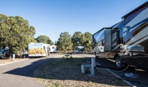 Several RVs and camping trailers parked at a scenic South America RV park, fully hooked up with electricity and water, ready for vacationers.