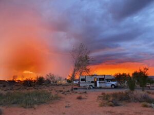 Wahweap RV & Campground – Inside Glen Canyon National Recreation Area 2 A camper parked at Wahweap RV & Campground under an orange sky at dusk.
