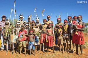 Several Aboriginal people posing for a photo in a forest, wearing red bandanas.