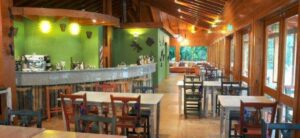 Dining area with tables, chairs, and stools at a counter.