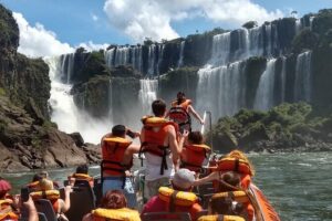 Several people in a boat wearing life jackets at iguazu falls